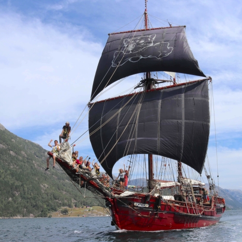 The ship with the black sails up and crew sailing near the coast ©Atyla ship Foundation